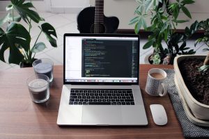 macbook-pro-beside-white-ceramic-mug-on-brown-wooden-table-k-rkfqsm4l4 MacBook Pro Desktop Scene with Plants & Guitar